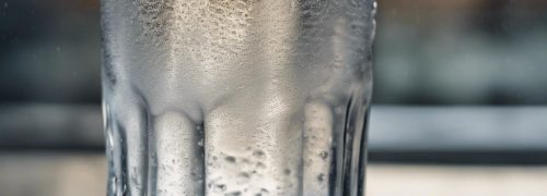 A hyper realistic photo of a glass of water with condensation, making it look refreshingly real.