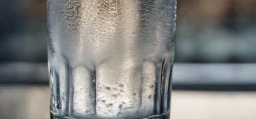 A hyper realistic photo of a glass of water with condensation, making it look refreshingly real.